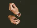 Mężczyzna zakłada smartwatch, by dowiedzieć się, jak ustawić krokomierz na rękę.