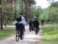 Grupa rowerzystów przemierza leśną ścieżkę. Każdy kilometr to spalony kcal, a widoki wynagradzają wysiłek.