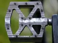 Metalowy pedał rowerowy z widocznymi śrubami. Dowiedz się, jak odkręcić pedały, by wymienić je lub wyczyścić.