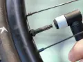 Zbliżenie na wentyl rowerowy i końcówkę pompki, gotowe do akcji. Dowiedz się, jak napompować rower, by jazda była przyjemnością.