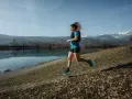 Kobieta biegnie nad jeziorem, w tle góry. Czas na 10 km!
