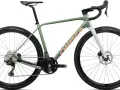 Zielony rower gravel Orbea z pomarańczowym napisem. Idealny na szutrowe trasy, bo gravel to wszechstronność.