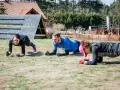 Trzy osoby ćwiczą w pozycji deski, przygotowując się do Runmageddonu.