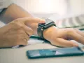Osoba dotyka ekranu smartwatcha, aby sprawdzić, jak włączyć bluetooth w smartwatch.