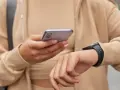 Osoba sprawdza na telefonie poziom stresu Garmin, nosząc smartwatch.