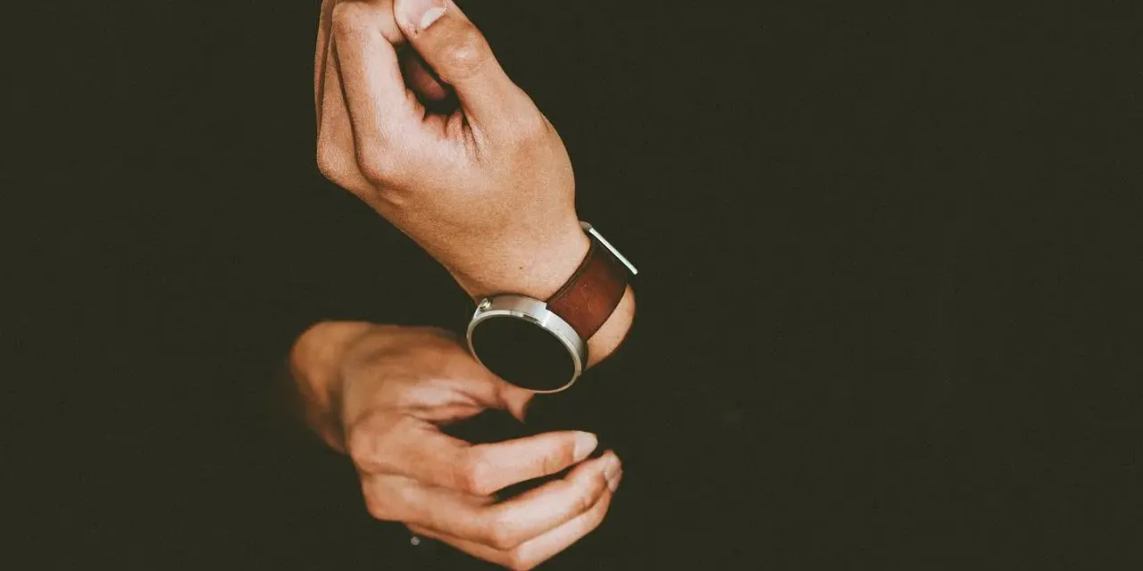 Mężczyzna zakłada smartwatch, by dowiedzieć się, jak ustawić krokomierz na rękę.