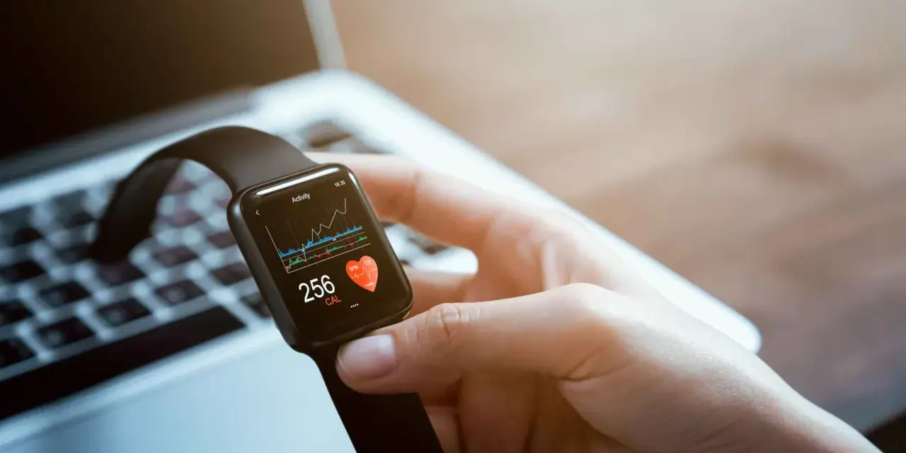 Dłoń trzyma smartwatch z ekranem aktywności, pokazującym 256 kcal. To idealny zestaw smartfon + smartwatch play dla aktywnych.