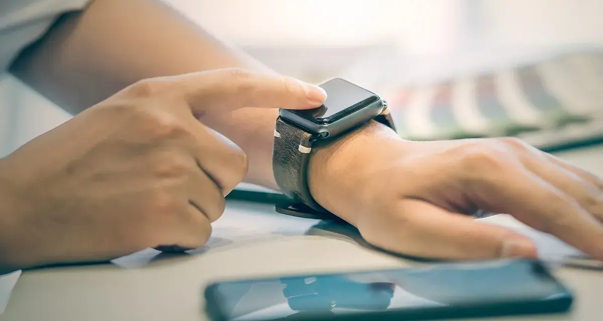 Osoba dotyka ekranu smartwatcha, aby sprawdzić, jak włączyć bluetooth w smartwatch.