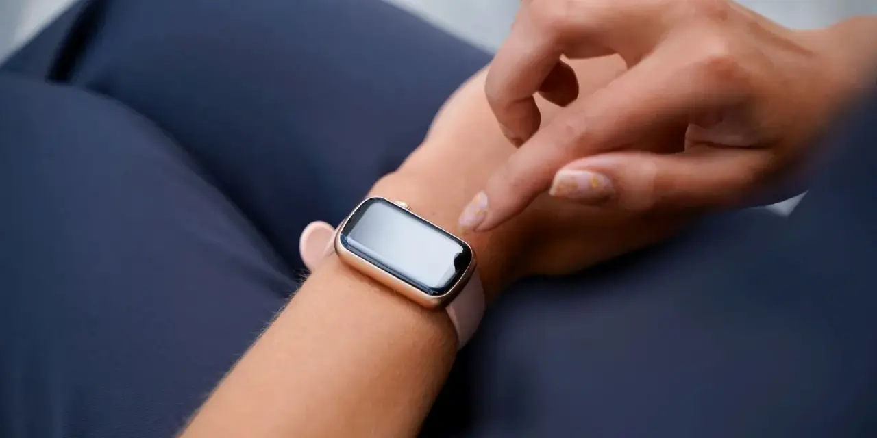 Dłoń próbuje obudzić smartwatch, który nie reaguje na ruch.