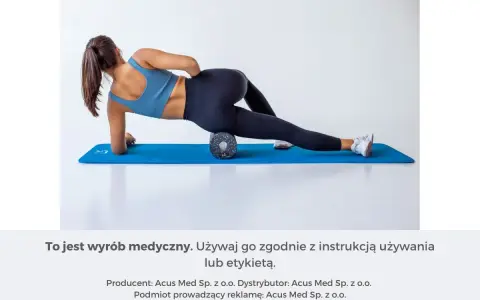Kobieta wykonuje rolowanie mięśni uda na wałku do masażu, leżąc na macie.