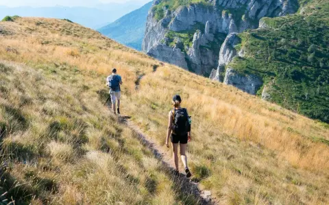 Dwie osoby wędrują po górskim szlaku. Zastanawiasz się, ile się idzie 1km w takich warunkach?