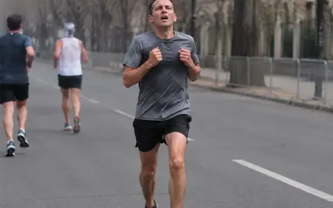 Mężczyzna biegnie w półmaratonie, zdeterminowany, by osiągnąć swój cel.