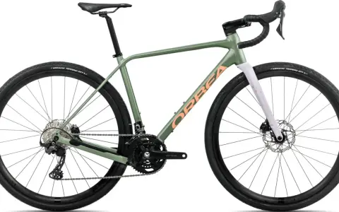 Zielony rower gravel Orbea z pomarańczowym napisem. Idealny na szutrowe trasy, bo gravel to wszechstronność.