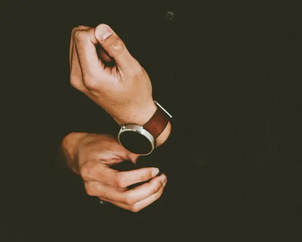 Mężczyzna zakłada smartwatch, by dowiedzieć się, jak ustawić krokomierz na rękę.