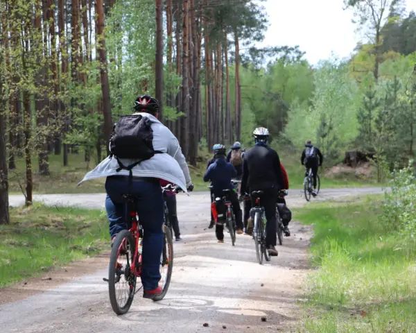 Grupa rowerzystów przemierza leśną ścieżkę. Każdy kilometr to spalony kcal, a widoki wynagradzają wysiłek.