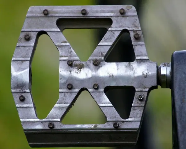 Metalowy pedał rowerowy z widocznymi śrubami. Dowiedz się, jak odkręcić pedały, by wymienić je lub wyczyścić.