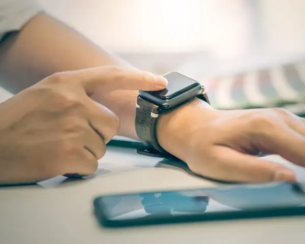 Osoba dotyka ekranu smartwatcha, aby sprawdzić, jak włączyć bluetooth w smartwatch.