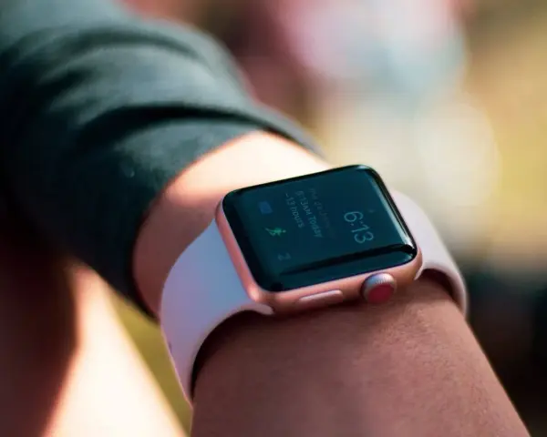 Złoty smartwatch z Google Play na nadgarstku, pokazuje godzinę 6:13 i informacje o aktywności.
