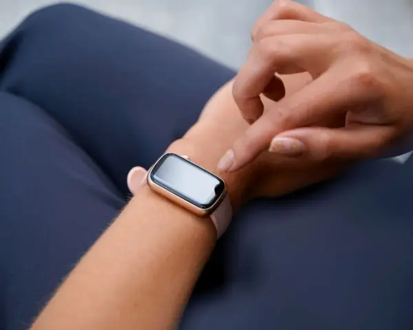 Dłoń próbuje obudzić smartwatch, który nie reaguje na ruch.
