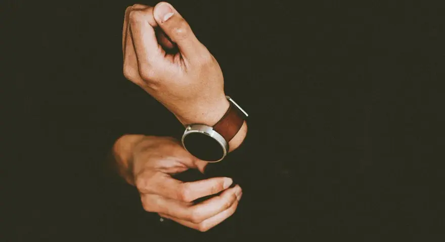 Mężczyzna zakłada smartwatch, by dowiedzieć się, jak ustawić krokomierz na rękę.