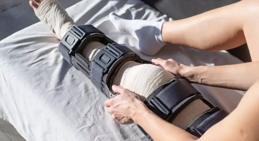 Instrukcja, jak założyć ortezę na kolano, z bandażem i stabilizatorem.