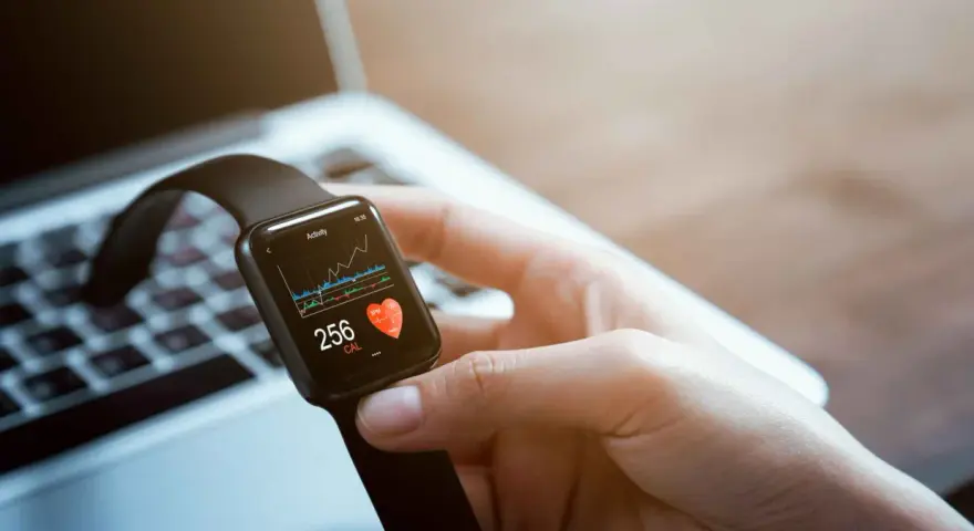 Dłoń trzyma smartwatch z ekranem aktywności, pokazującym 256 kcal. To idealny zestaw smartfon + smartwatch play dla aktywnych.