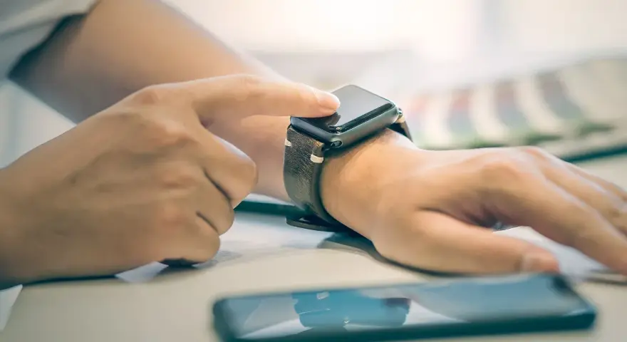 Osoba dotyka ekranu smartwatcha, aby sprawdzić, jak włączyć bluetooth w smartwatch.
