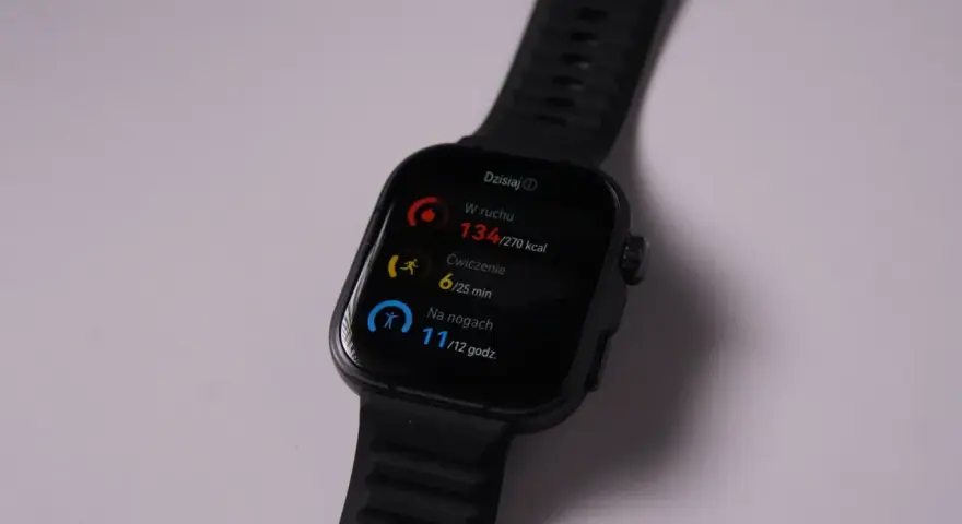 Czarny zegarek fit pro pokazuje dzienne postępy: 134 kcal spalonych, 6 min ćwiczeń i 11h na nogach.