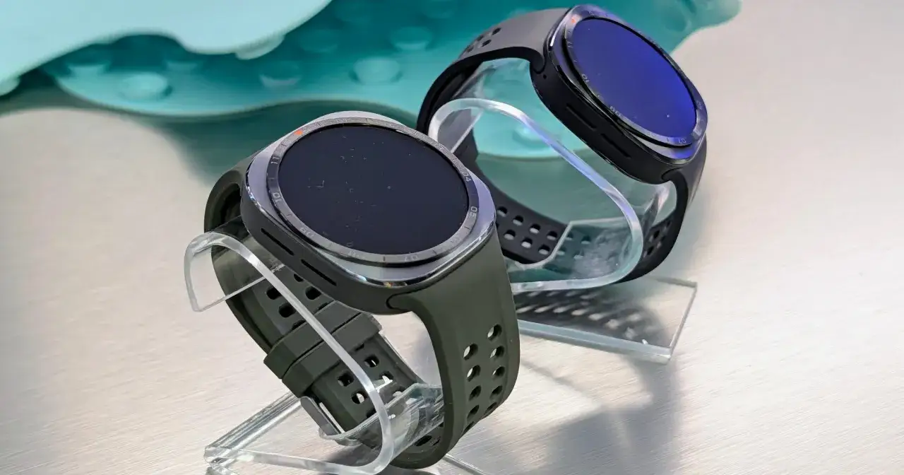 Dwa eleganckie smartwatche, jeden zielony, drugi czarny, prezentowane na przezroczystych stojakach. Idealny zestaw smartfon + smartwatch Play dla aktywnych.