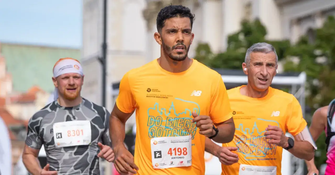 Trzech biegaczy w maratonie. Jeden z nich, Antonio, ma numer 4198. Jak przygotować się do maratonu? Trening i determinacja.
