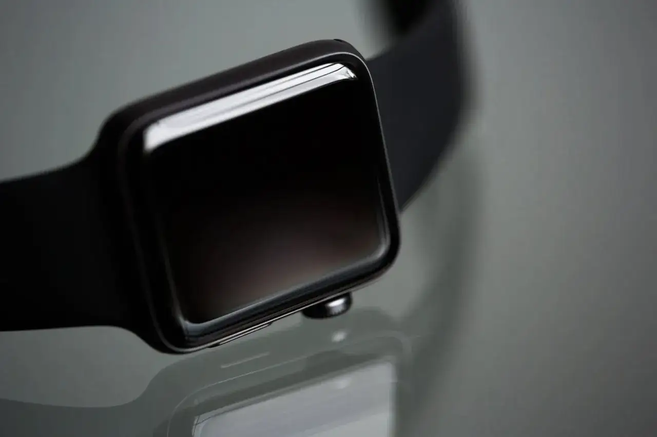 Czarny zegarek smartwatch nie chce się włączyć. Ekran jest ciemny, a jego błyszcząca powierzchnia odbija światło.