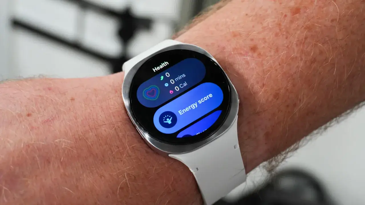 Smartwatch z cisnieniomierzem na ręce, wyświetla dane o zdrowiu, w tym tętno i wynik energii.