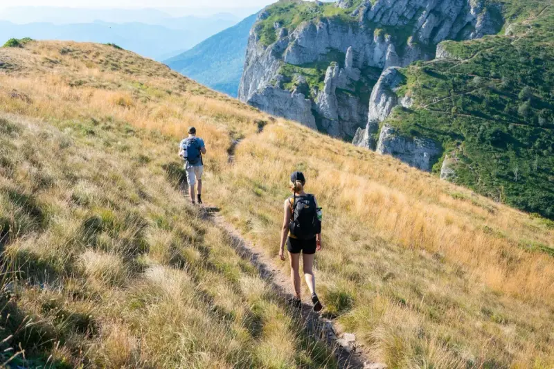 Dwie osoby wędrują po górskim szlaku. Zastanawiasz się, ile się idzie 1km w takich warunkach?